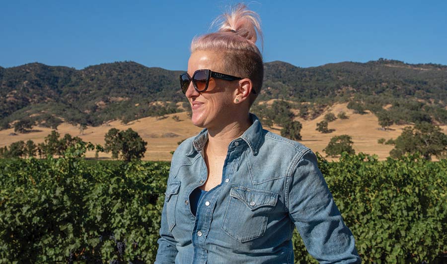 Bezel winemaker Jane Dunkley standing in Paso Robles California vineyards with mountains in the background
